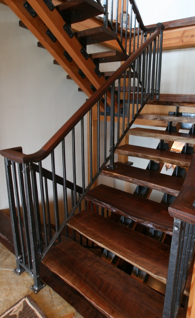 Hand-hammered metal joins walnut rails and live edge treads in a Lake Erie home.