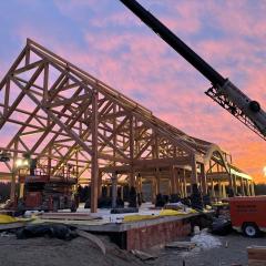 A dramatic view Acadia National Park Gateway Center timber frame during construction. this 11,000 square-foot building features 460 individual timbers and includes trusses up to 42 feet long.