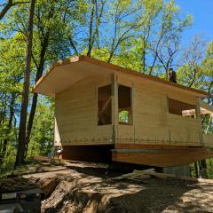A design that commonly integrates glulam has the upper story of a house sitting atop large, sturdy beams for a expanded footprint that floats above the landscape.