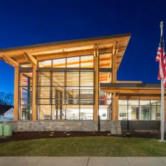 Glulam posts and beams infuse this building with character, particularly lit up against the night sky.