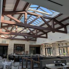 The custom trapezoid shape of these glulam trusses allows for enough headspace to accommodate a spacious skylight.